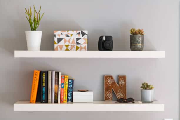 floating shelves replacing nightstand in small bedroom